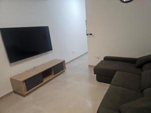 a living room with a couch and a flat screen tv at Maisonette Gzira in Il-Gżira