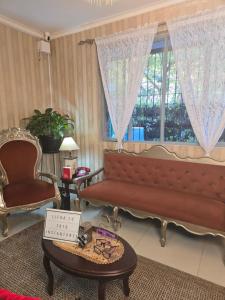 a living room with a couch and a table and a window at Apto Gatinho in Rio de Janeiro
