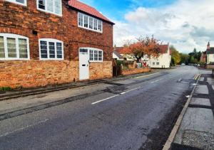 an empty street in front of a brick building at Spacious & Luxury 2BR Flat in Calverton in Calverton