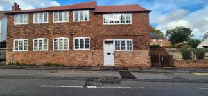 a brick house with a white door on a street at Spacious & Luxury 2BR Flat in Calverton in Calverton