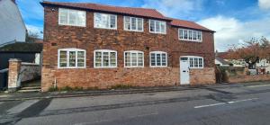 a brick building with white windows on a street at Spacious & Luxury 2BR Flat in Calverton in Calverton