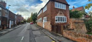an empty street with a brick building on the side of the road at Spacious & Luxury 2BR Flat in Calverton in Calverton