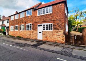 a brick building with a white door on a street at Spacious & Luxury 2BR Flat in Calverton in Calverton