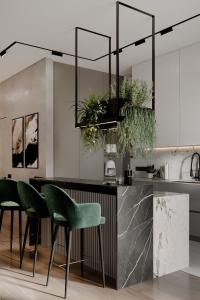 a kitchen with a counter with green chairs at Ático de lujo para 7 personas in Cartagena de Indias