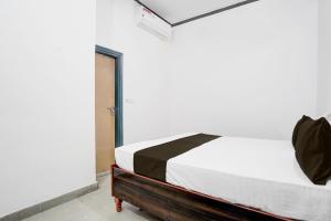 a bedroom with a bed in a white room at Hotel O Shubh Residency in Bhundsi