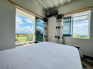 una camera da letto con un letto e una grande finestra di Finca La Blanca a Doradal