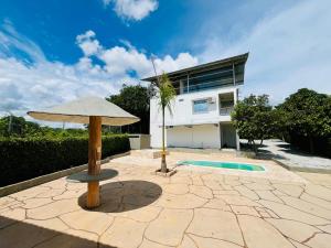 patio con ombrellone e edificio di Finca La Blanca a Doradal