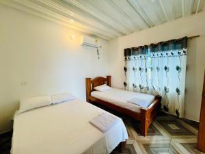 una stanza con due letti e una finestra di Finca La Blanca a Doradal Altre 43 foto