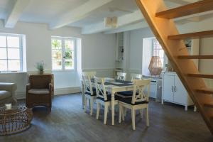 una cucina e una sala da pranzo con tavolo e sedie di Ty pesker a Jouvente