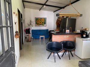 a room with two chairs and a kitchen with a counter at El Guadualito in Pitalito