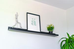 uno scaffale nero con un quadro e una pianta di Jungle House Columbus Short North Downtown Free Parking - Steps to Convention Center & Nationwide Arena - 2BR Luxury Home - Sleeps 12 - Over 5,800 Five Star Stays a Columbus