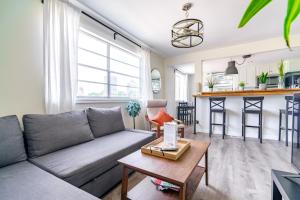 un soggiorno con un divano e un tavolo di Jungle House Columbus Short North Downtown Free Parking - Steps to Convention Center & Nationwide Arena - 2BR Luxury Home - Sleeps 12 - Over 5,800 Five Star Stays a Columbus