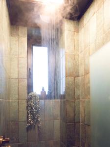 a bathroom with a shower with a window at Urban Deluxe Calea Victoriei 100 Sauna and Jacuzzi in Bucharest +5 photos