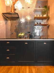 a kitchen with a black counter and a sink at Urban Deluxe Calea Victoriei 100 Sauna and Jacuzzi in Bucharest