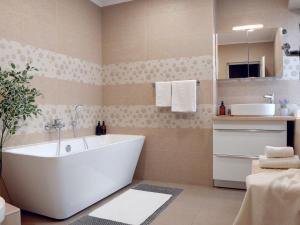 a bathroom with a white tub and a sink at Urban Deluxe Calea Victoriei 100 Sauna and Jacuzzi in Bucharest