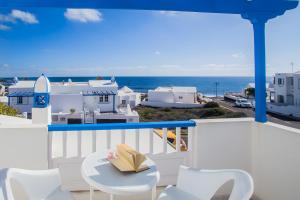 een balkon met een tafel en stoelen en de oceaan bij Villa Tabaiba in Arrieta
