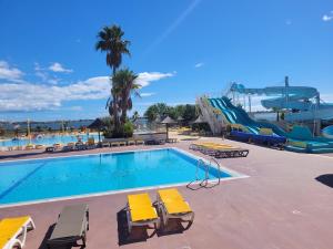 a swimming pool with yellow chairs and a water slide at bb - Confort & charme - Au Cœur de l'Occitanie, 3 ch,2 sdb, entre mer et campagne in Lattes