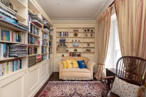 a library with bookshelves and a chair in a room at The Old Vicarage in Wadebridge