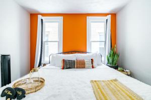 a bedroom with an orange wall and a bed at Jungle House Luxury Stays - Columbus Downtown Short North in Columbus +52 photos