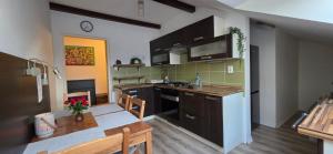 a kitchen with brown cabinets and a table and a dining room at Apartman v širšom centre Martina SEVER in Martin +4 photos