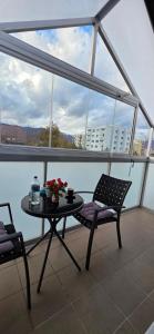 a table and chairs on a balcony with a view of a city at Apartman v širšom centre Martina SEVER in Martin
