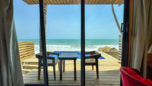 a table and chairs on a deck with the ocean at Adepa in Kokrobite