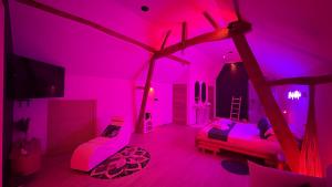 CrisnéeL'Améthyste的粉红色的客房设有两张床和电视。 更多20张照片