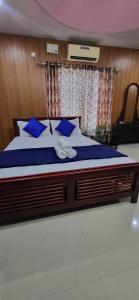 コーラムにあるNima Residencyの青い枕が付いた大きなベッドのある寝室