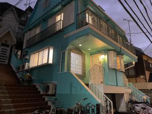 a blue house with stairs leading up to it at Aila apartment in Tokyo
