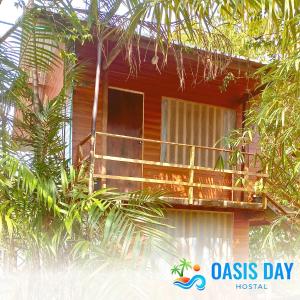 a red house with a balcony and trees at Hostal Oasis Day in Buenaventura +7 photos