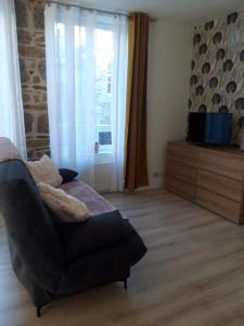 a living room with a couch and a window at TINCHEBRAY Centre ville in Tinchebray