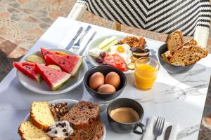 una mesa cubierta con platos de alimentos y huevos para el desayuno en Bella Vista Beach Hotel, en Benitses