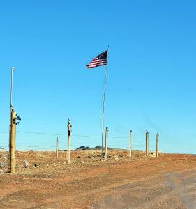 Eine amerikanische Flagge auf einer Stange mitten auf einer unbefestigten Straße in der Unterkunft Alien Acres UFO Campground in Sun Valley