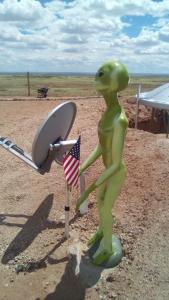 Eine Statue einer Person, die eine amerikanische Flagge und ein Surfbrett hält. in der Unterkunft Alien Acres UFO Campground in Sun Valley