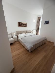 a white bedroom with a large bed and a couch at Casa di Zoja 2 in Arona