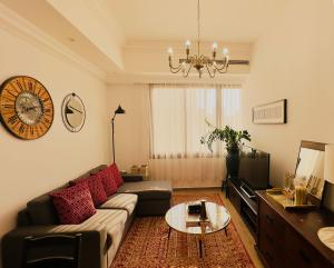 a living room with a couch and a table at Mid-Century Modern Comfort 1BR in Abu Dhabi