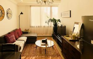 a living room with a couch and a table at Mid-Century Modern Comfort 1BR in Abu Dhabi +28 photos