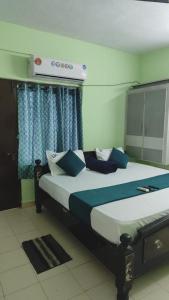 a bedroom with a bed with blue and white pillows at lighten homestay in Visakhapatnam