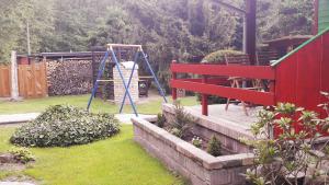 ein Spielplatz mit einer roten Bank und einer Schaukel in der Unterkunft Ferienhaus Sonneneck mit Motorboot und Kanu in Basedow + 9 Fotos