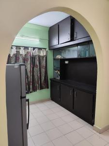 an archway in a kitchen with a refrigerator and cabinets at lighten homestay in Visakhapatnam