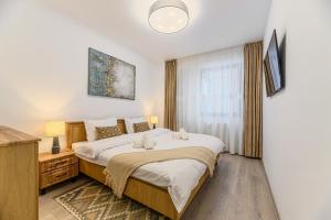 a bedroom with a large bed and a window at Luxury 2BR Apartment - Amazing Terrace in Braşov +27 photos