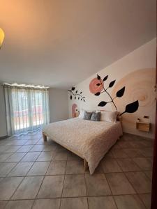 a bedroom with a bed with a flower mural on the wall at Villa Ninnì in Treglio