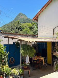 a house with a table and a mountain in the background at Buena Onda Suites in Abraão