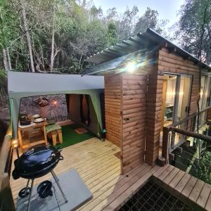 una piccola cabina con terrazza e griglia di Squirrels Rest Treetop Glamping a Knysna
