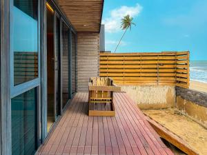 un banco de madera sentado en una terraza cerca de la playa en Nuntaa, en Kokrobite