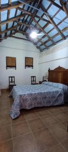 ein Schlafzimmer mit einem Bett mit einer blauen Decke darauf in der Unterkunft El Cortijillo de la Marquesa in Villar