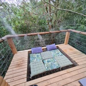 un ponte con cuscini e un braciere su un ponte di Squirrels Rest Treetop Glamping a Knysna