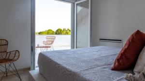 una camera da letto con un letto e una porta scorrevole in vetro di Residenza del Duca a Martina Franca Altre 88 foto