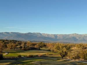 a view of a golf course with mountains in the background at Hospedium Hotel Valles de Gredos Golf in Talayuela