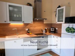 a kitchen with white cabinets and a sink at Ferienwohnung am Maximilianpark Hamm in Hamm +74 photos